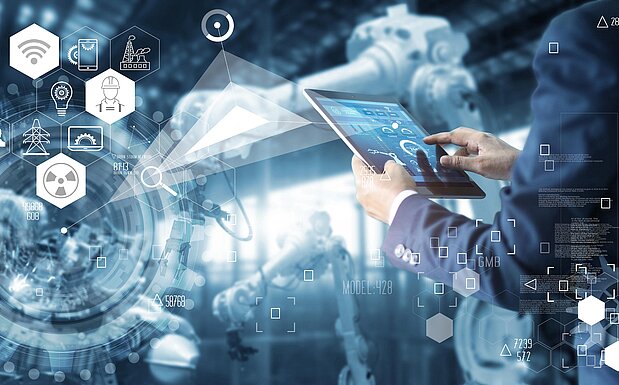Person bedient ein Tablet in einer automatisierten Fabrikumgebung mit Robotern und digitalen Symbolen für Vernetzung und Industrie 4.0.