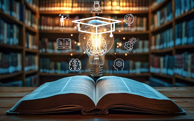 Open book with light bulb with graduation hat