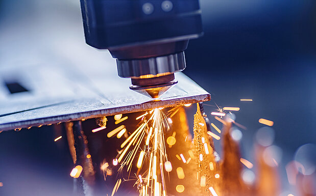 CNC-Lasermaschine schneidet Blech mit Lichtfunken